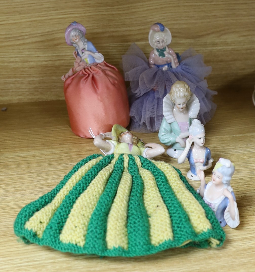 Six pin Dollie porcelain tea cosies, tallest 10cms